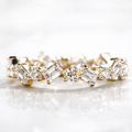 Moissanite full eternity ring with emerald and round cut stones in 18K gold